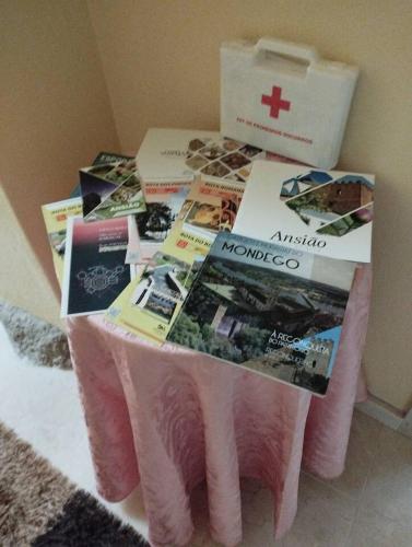 a table with a pile of magazines on top of it at Casa do Ribeiro in Chão de Couce