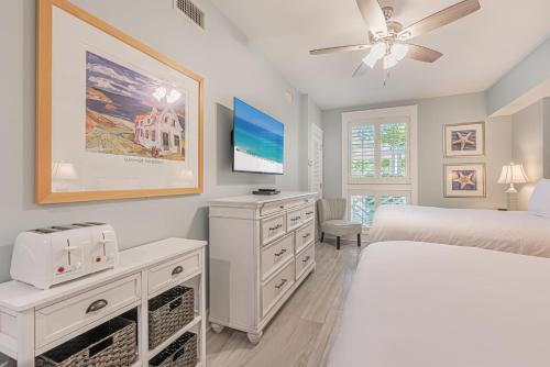 ein weißes Schlafzimmer mit einem Bett und einem Deckenventilator in der Unterkunft Market Street Inn 339 in Destin
