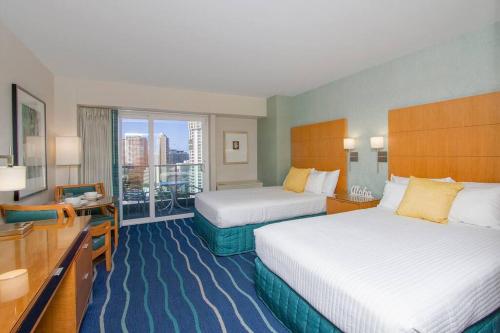 a hotel room with two beds and a balcony at Amazing view from your balcony Walk to the beach 2420 in Honolulu