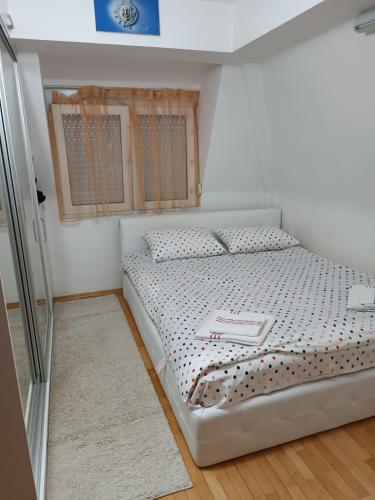 a bedroom with a white bed with a tray on it at SKY APARTMENTS in Kumanovo