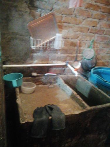 a kitchen with a sink in a brick wall at Casa familiar in El Apogeo