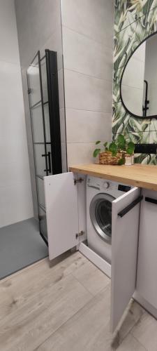 eine Küche mit einer Waschmaschine und einem Spiegel in der Unterkunft CITY VIEW Saperów II - przy centrum klimatyzacja in Świdnica