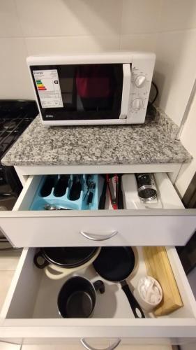 a microwave oven sitting on top of a kitchen counter at Vid_y_Olivo. Cómodo departamento en el centro de Maipú in Maipú