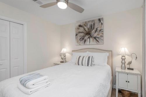 Un dormitorio blanco con una cama blanca con toallas. en Gulf Breeze Home/Remodeled 2Bdr, en Gulf Breeze