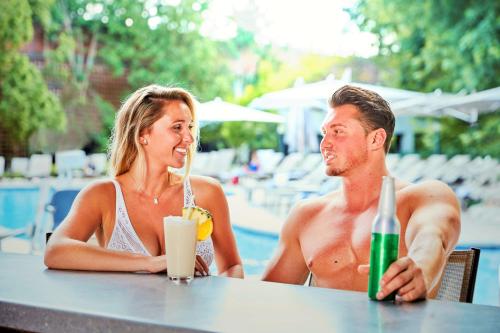 a man and woman sitting at a table by a pool at Hilton Short Hills in Short Hills