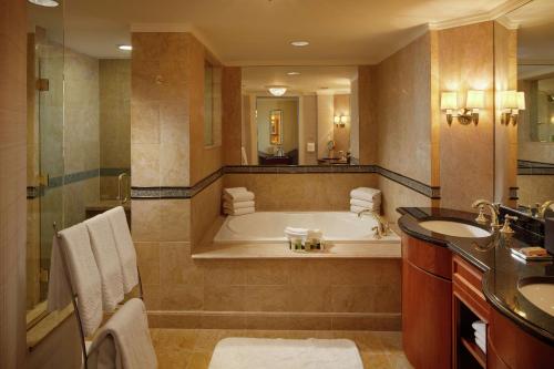 a large bathroom with a tub and a sink at Hilton Short Hills in Short Hills