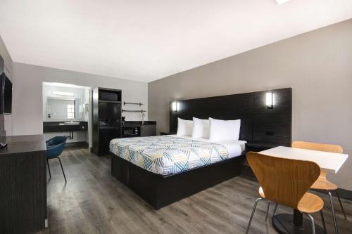 um quarto de hotel com uma cama, uma secretária e cadeiras em Studio 6 San Antonio TX Northwest Medical Center em San Antonio