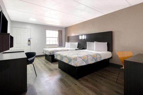 a hotel room with two beds and a desk at Studio 6 San Antonio TX Northwest Medical Center in San Antonio