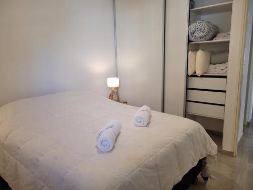 1 dormitorio con 1 cama con toallas en Next door departamento con cochera en Godoy Cruz