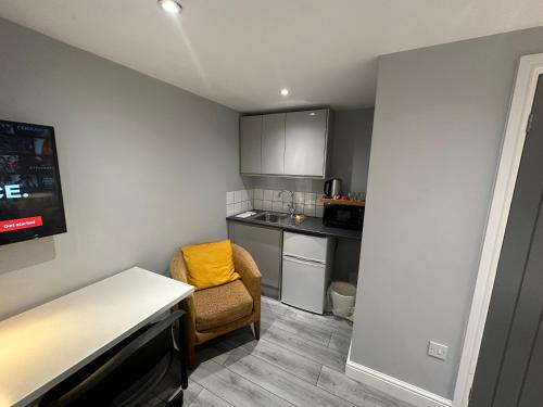 uma pequena cozinha com uma mesa e uma cadeira em Modern Luxury Private Detached 1 Double Bedroom Studio Apartment - Super Fast Wifi em Luton