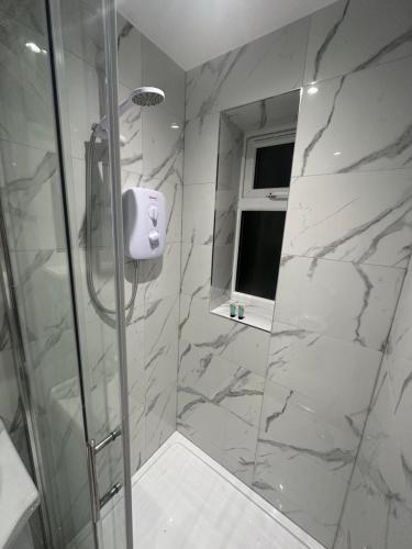 a bathroom with a shower with marble walls at Modern Luxury Private Detached 1 Double Bedroom Studio Apartment - Super Fast Wifi in Luton