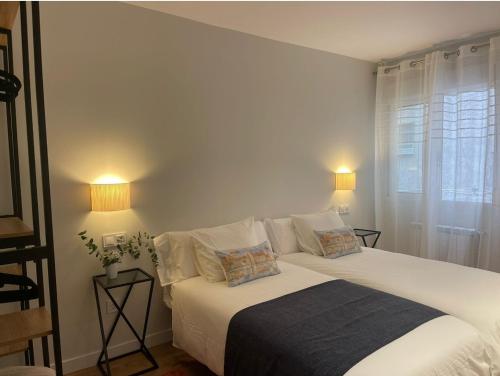 1 dormitorio con 1 cama con sábanas blancas y ventana en APARTAMENTO 4 PAX RECIÉN REFORMADO EN EL CENTRO DE SANTANDER, en Santander