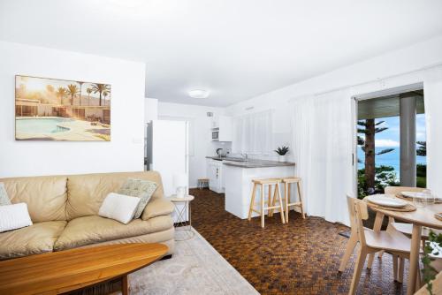 a living room with a couch and a table at Beach View Mollymook in Mollymook