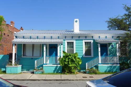 a blue house with a tin roof on a street at Stella Blue - 8 in Savannah