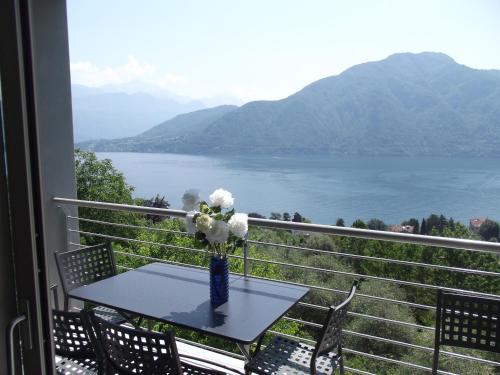 a table with a vase of flowers on a balcony at Residenza Simona in Mezzegra