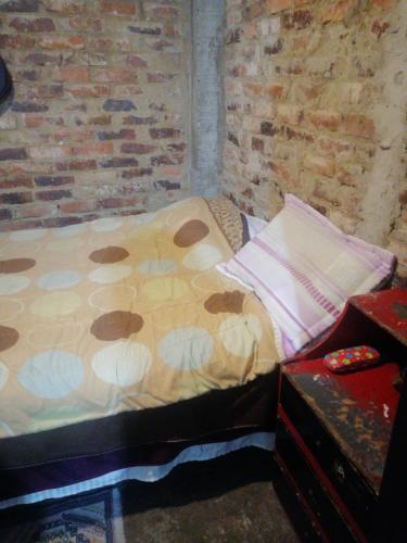 Cama pequeña en habitación con pared de ladrillo en Casa familiar en Soacha en El Apogeo