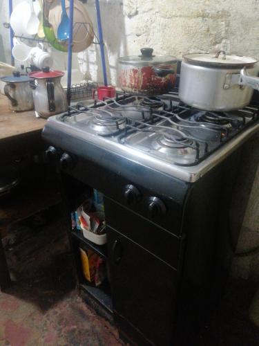 a stove with pots and pans on top of it at Casa familiar en Soacha in El Apogeo