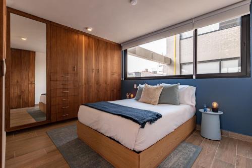 a bedroom with a large bed and a large window at Roma Norte Trendy Apartments by VIATO in Mexico City