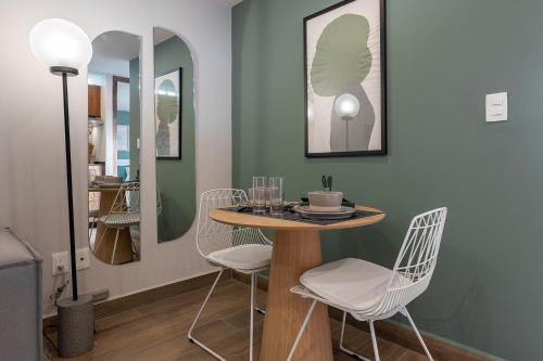 a dining room with a table and white chairs at Roma Norte Trendy Apartments by VIATO in Mexico City