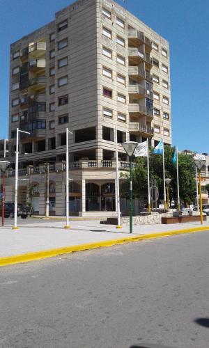 ein großes Gebäude mit Flaggen davor in der Unterkunft Dpto AR in San Clemente del Tuyú