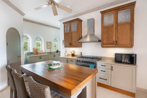 a kitchen with a wooden table and a stove at Sugar Hill - Fiddlesticks villa in Saint James
