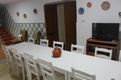 una camera con tavolo, sedie e televisore di Casa Rural El Nini a La Coronada