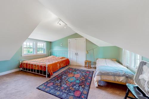 un dormitorio en el ático con 2 camas y una alfombra en Meadow Farmhouse, en Sedgwick