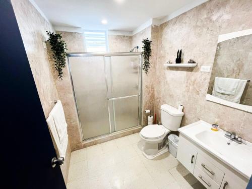 a bathroom with a shower and a toilet and a sink at Pedazo del Mar Beach House in Salinas