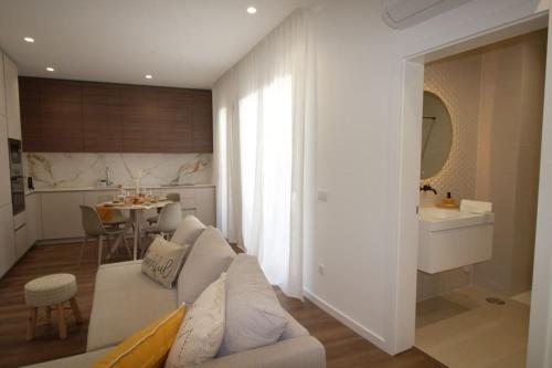 uma sala de estar com um sofá branco e uma cozinha em Refúgio do Sossego em Fátima