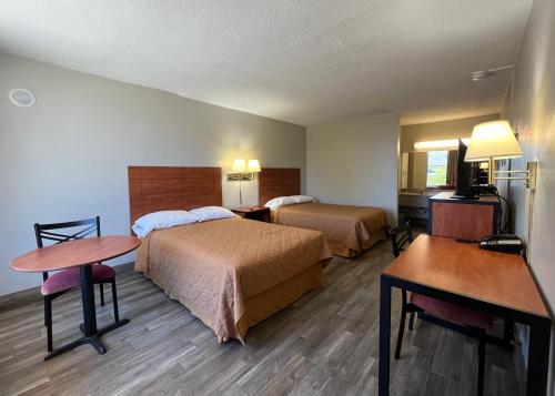 a hotel room with two beds and a desk at EZ Travel Inn College Station in College Station