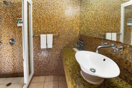 a bathroom with a sink and a shower at Hotel Cayman Suites in Monterrico