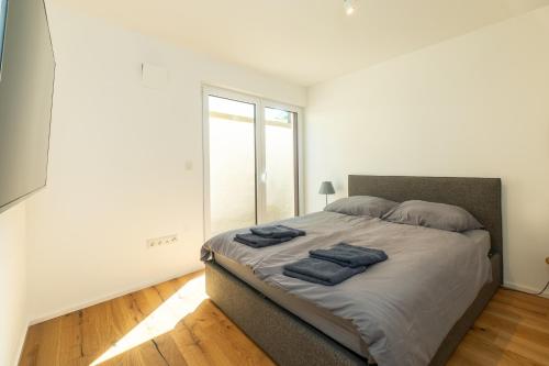 1 dormitorio con 1 cama con 2 toallas azules en Möbliertes Wohnen I Eltville central, en Eltville am Rhein