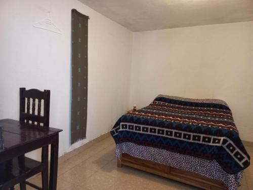 - une chambre avec un lit, une table et une chaise dans l'établissement El Rinconcito de San Cris, à San Cristóbal de Las Casas
