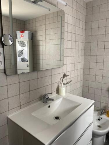 a white bathroom with a sink and a mirror at Casa Rural El Nini in La Coronada