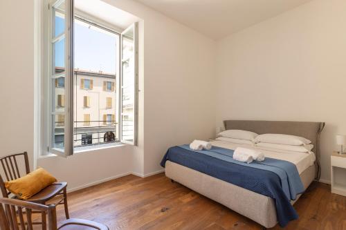 een slaapkamer met een bed en een groot raam bij MC House Como con Posto Auto in Como