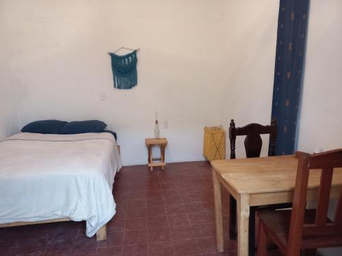 - une chambre avec un lit et une table en bois dans l'établissement El Rinconcito de San Cris, à San Cristóbal de Las Casas