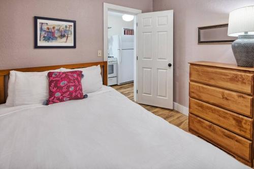 a bedroom with a white bed with a red pillow at Downtown Drift-Hot Tub,Sauna,Bikes,Pet Friendly in Arcata