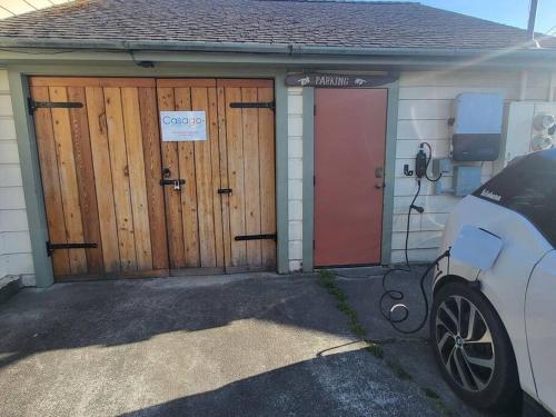 a house with two wooden doors and a car parked in front at Downtown Drift-Hot Tub,Sauna,Bikes,Pet Friendly in Arcata