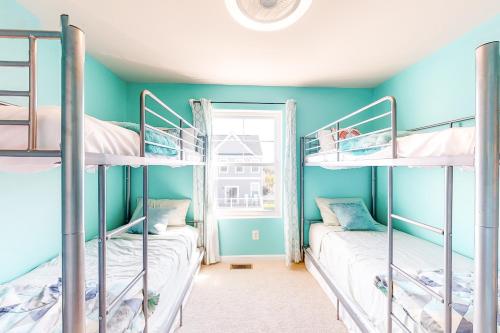two bunk beds in a room with blue walls and a window at Seaside Village --- #3 in Ocean City