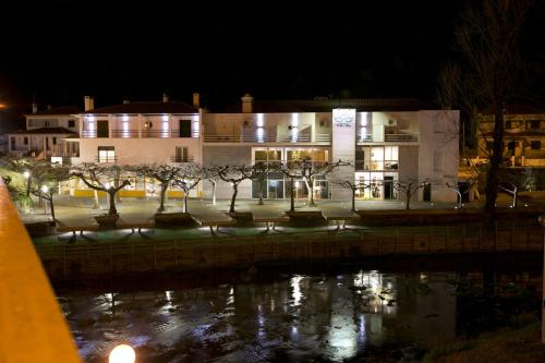 a building at night with a pond in front of it at Sever Rio Hotel in Marvão
