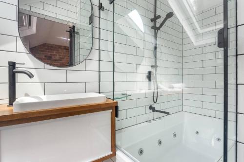 La salle de bains est pourvue d'une baignoire, d'un lavabo et d'un miroir. dans l'établissement A Charming Sunny Terrace in the Heart of Newtown, à Sydney