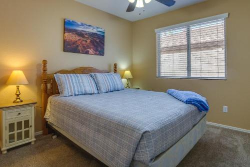 a bedroom with a bed with a blue bedspread and a window at Bright Peoria Home with Gas Grill and Fire Pit! in Peoria