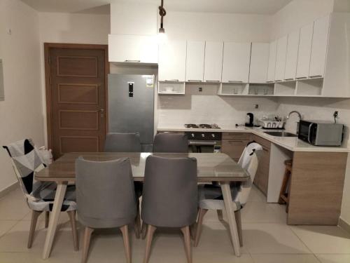 a kitchen with a wooden table and chairs in it at مارسيليا بيتش 4 in Sīdī ‘Abd ar Raḩmān