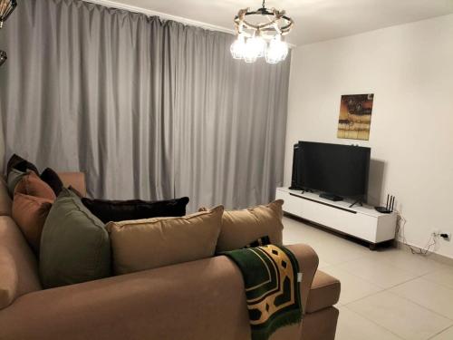 a living room with a couch and a flat screen tv at مارسيليا بيتش 4 in Sīdī ‘Abd ar Raḩmān