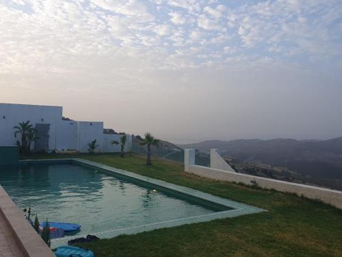 Villa avec vue panoramique في طنجة: حمام سباحة على جانب المنزل