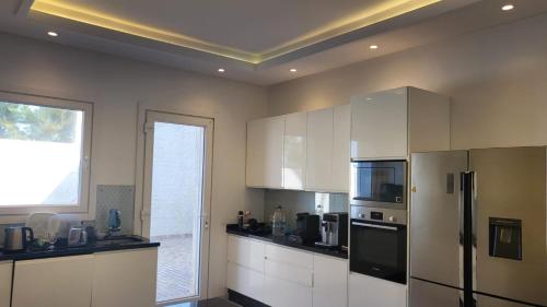 a kitchen with white cabinets and a refrigerator at Villa avec vue panoramique in Tangier