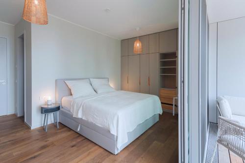 a bedroom with a white bed and a small table at Marina Maisonette Seeblick mit Pool und Sauna in Bad Saarow