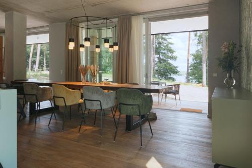 une salle à manger avec une grande table et des chaises dans l'établissement Marina Maisonette Seeblick mit Pool und Sauna, à Bad Saarow