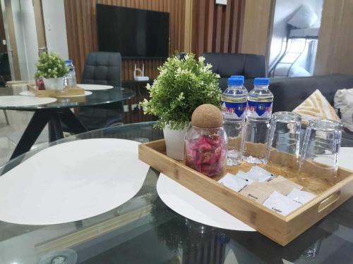2BR SMDC Bloom Residences Near NAIA Wi-fi +Netflix في مانيلا: علبة ماء على طاولة زجاجية