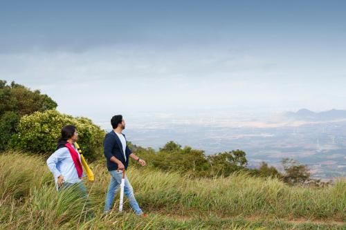 a man and woman standing on top of a hill at 31st December Farms And Estates Munnar in Munnar